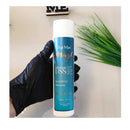 Agi Max Intense Liss shampoo bottle held by a gloved hand with a plant in the background