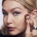Woman applying makeup with a brush to her face