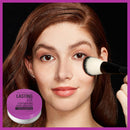 Woman applying makeup with a brush, Maybelline product visible