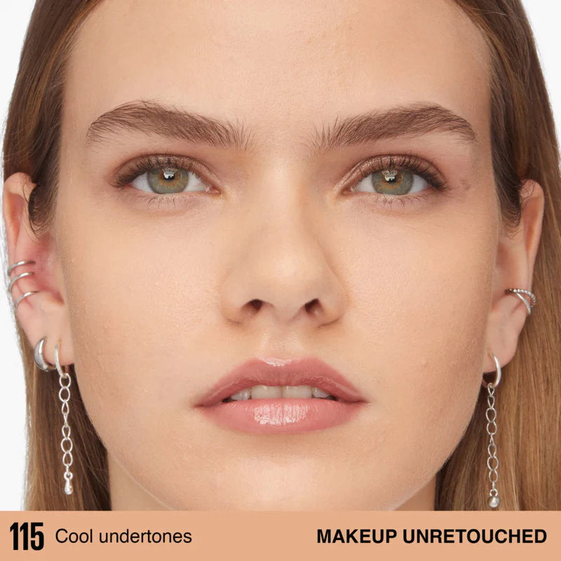 Close-up of a woman's face with earrings, showcasing makeup unretouched.