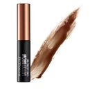 Maybelline Tattoo Brow Long Lasting Ink permanent brow tint in a black tube with a metallic rose gold cap, shown next to a brown product swatch on a white background.
