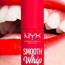 NYX Smooth Whip Matte Lip Cream 12 Icing on Top  - A close-up of a red NYX Professional Makeup Smooth Whip lip product tube centered in front of an open mouth with bright red lipstick.